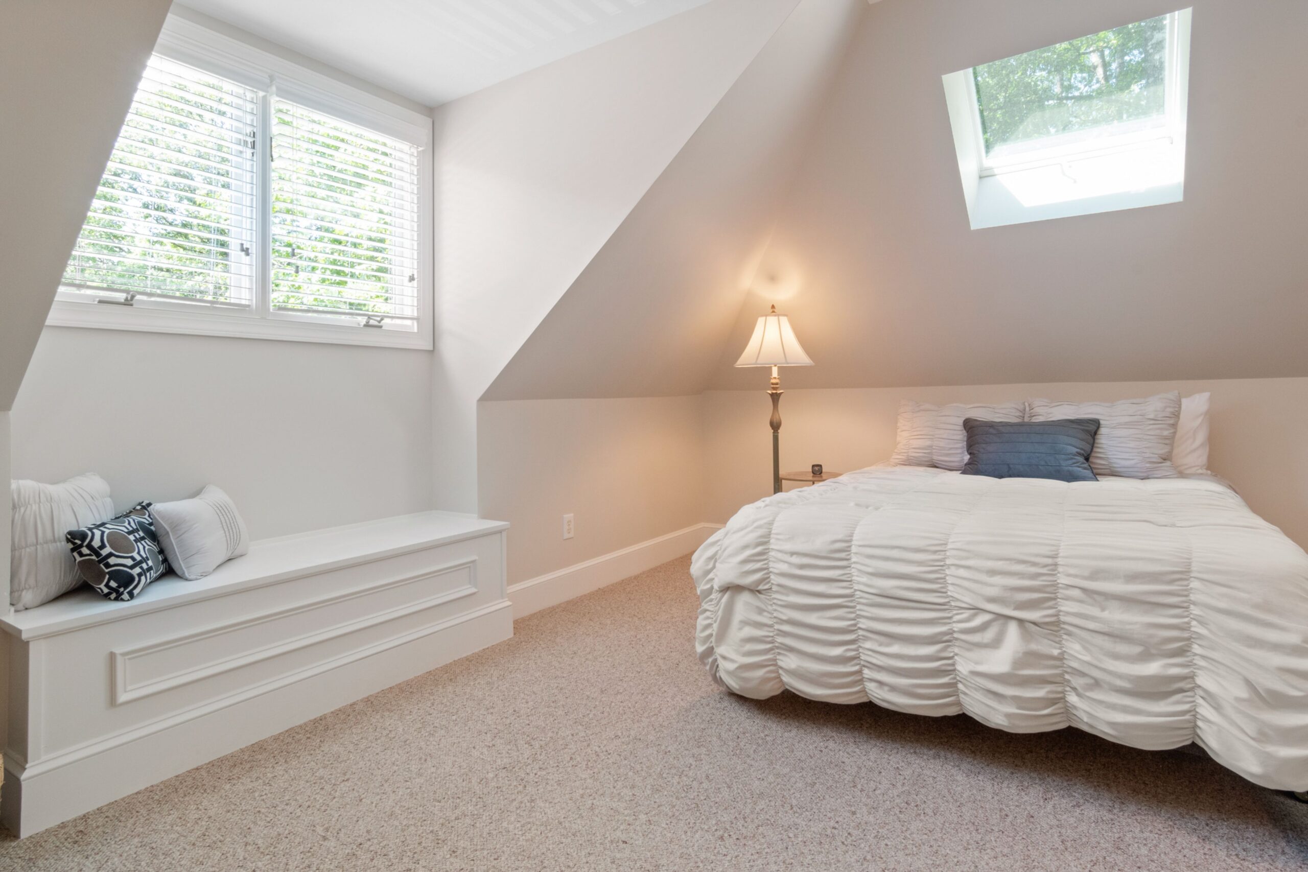 "Bright finished loft bedroom with dormer window, window seat, skylight and sloped ceilings"